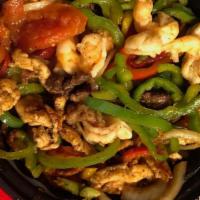 Fajitas · Sizzling cast iron skillet with red, yellow, & green peppers, tomatoes, onions and garlic se...
