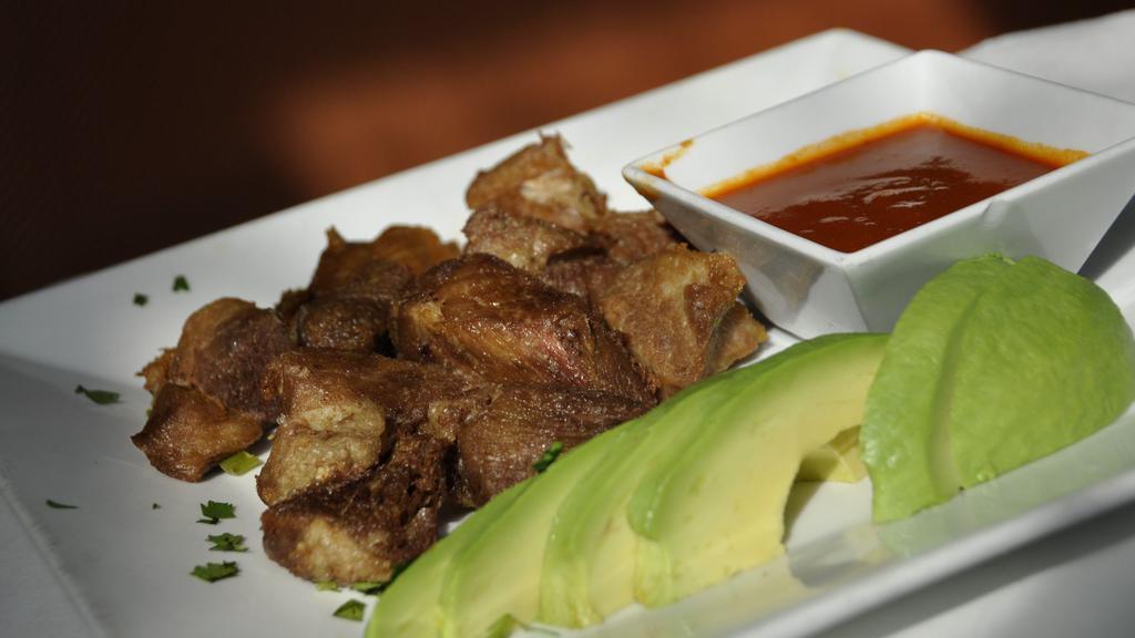 Carnitas De Puerco · Tender fried pork, avocado slices served with a chipotle salsa. Spanish rice, frijoles, and tortillas.