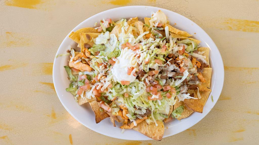 Nachos El Mariachi · Cheese and bean nachos topped with your choice of grilled chicken strips or beef steak, with cheese sauce. Topped with lettuce, tomato and sour cream.