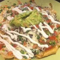 Nachos · Vegetarian. Melted cheese and refried beans on a bed of warm chips, topped with lettuce, tom...
