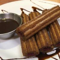 Raspberry Churros · Raspberry filled churros served with chocolate sauce..