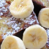 Banana Foster French Toast · Three slices of French toast with warm foster sauce and topped with sliced bananas.