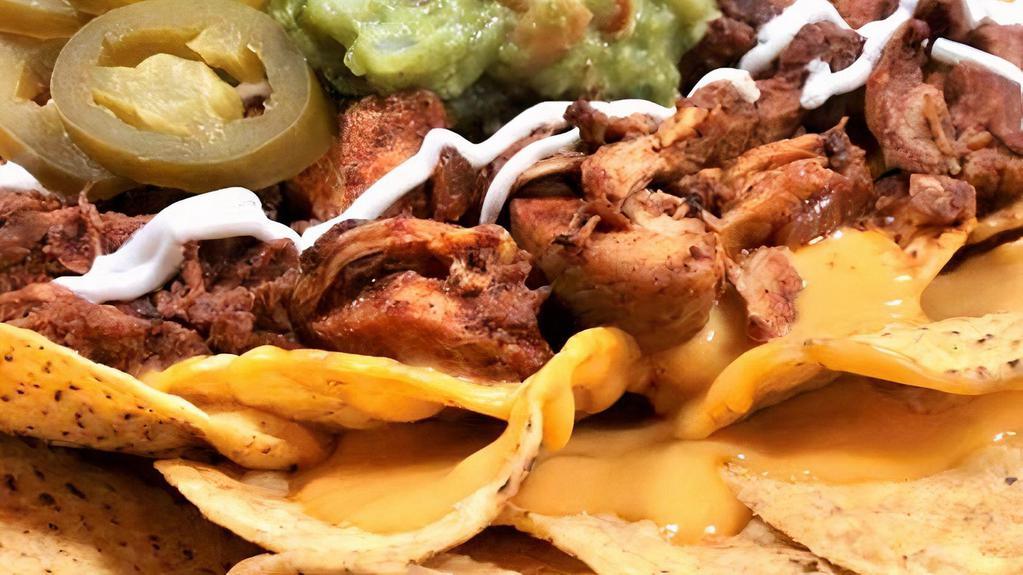 Al Pastor Nachos · Classic al pastor nachos with melted cheese, pico de gallo, beans, and your choice of toppings.
