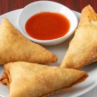 Sambussa · Vegan. Three pieces. Fried dumplings, served with a sweet and spicy honey awaze sauce. Conta...