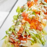 Burrito Azteca · Filled with ground beef or shredded chicken, topped with cheese sauce and tomatillo, lettuce...