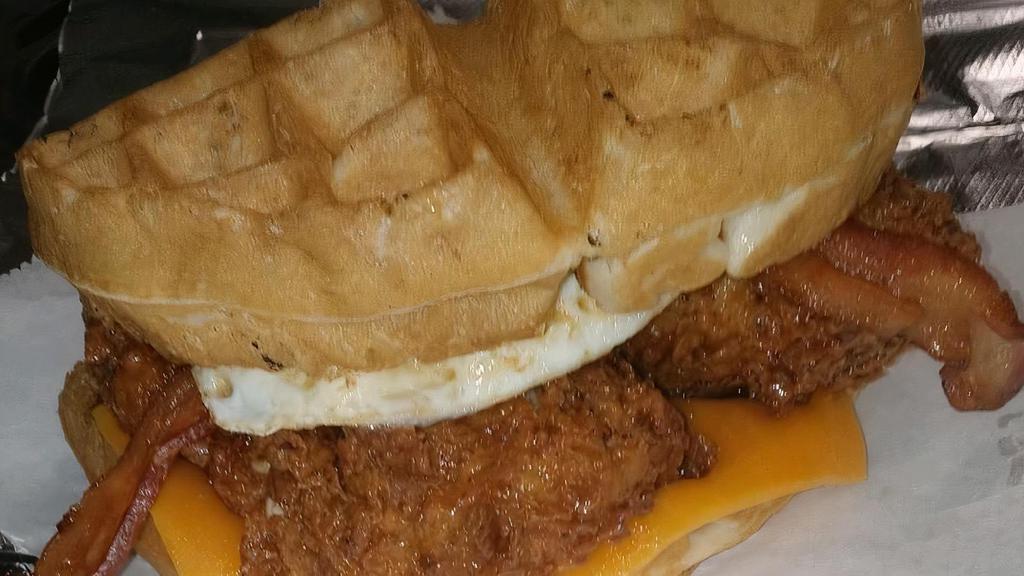 Stuffed Waffle Sammy · Fresh off the Iron Waffle Cut in Half and stuffed with cheddar cheese, bacon, Honey dipped Chicken Tenders, and  topped with an over easy egg!