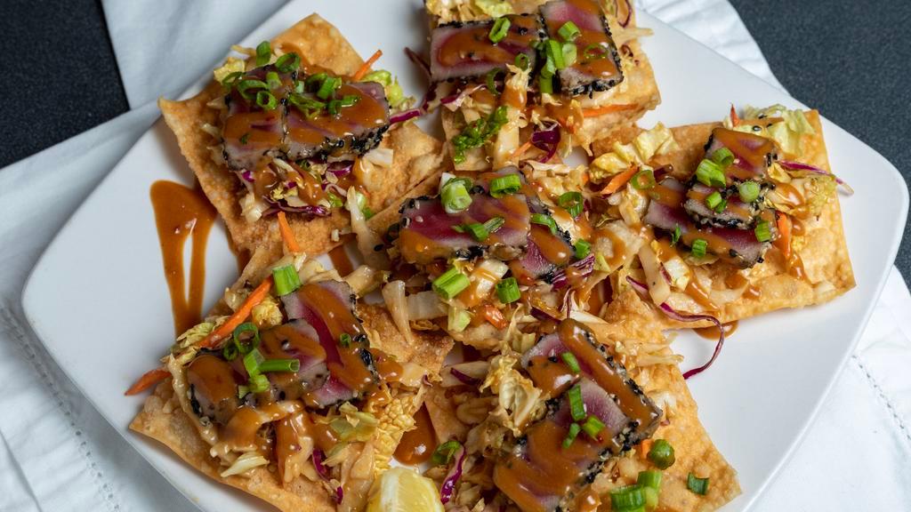 Tuna Nachos · Seared ahi tuna on fried wontons with Napa cabbage slaw and thai peanut sauce.