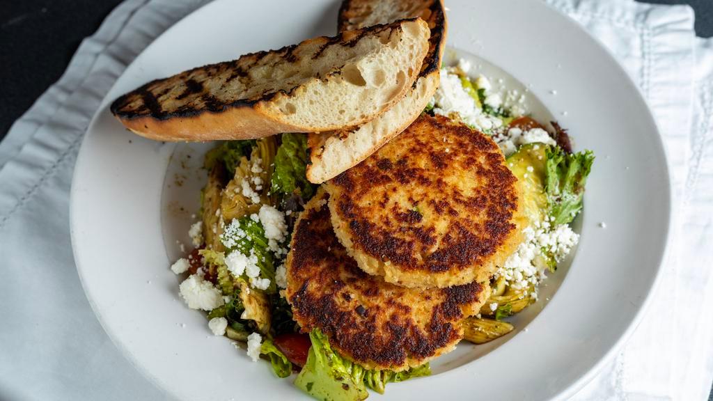 Crab Cake Salad · Lump crab cakes served on mixed greens with tomato, red onion, penne pasta, cucumber, artichoke hearts, grilled baguette, and feta cheese tossed in a balsamic pesto vinaigrette.