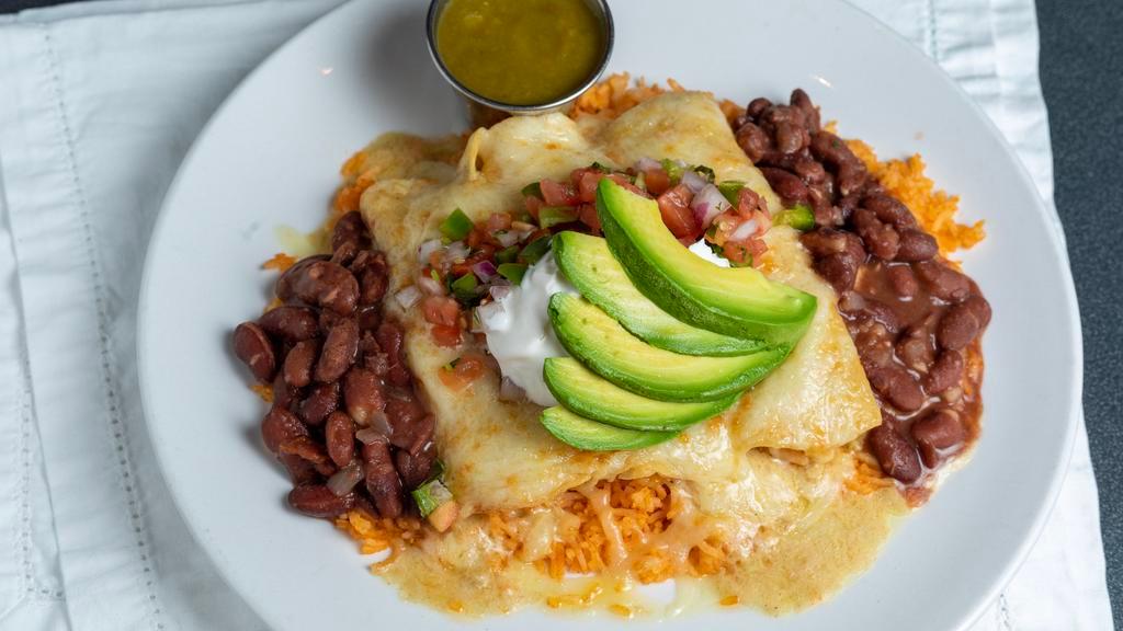 Seafood Enchilada · Corn tortillas filled with shrimp, scallops, and salmon and topped with melted jack cheese and cumin cream sauce. Served with rice, beans, fresh avocado, salsa, and sour cream.