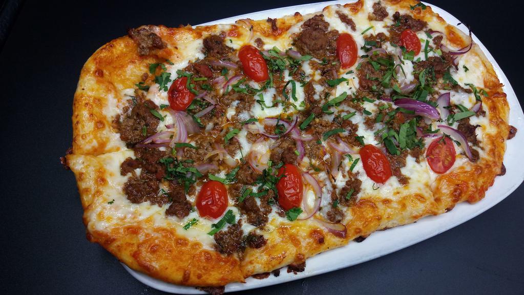 Beef Cilantro Pizza · stir-fried Beef tenderloin, onions, peppers, tomatoes, mozzarella provolone cheese, and cilantro leaves.