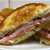 Turkey Club Sandwich · Try this definite favorite.....thinly sliced turkey breast topped with provalone cheese, cri...