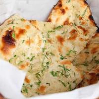 Naan · Traditional hand-tossed bread, freshly baked in a tandoor clay oven.