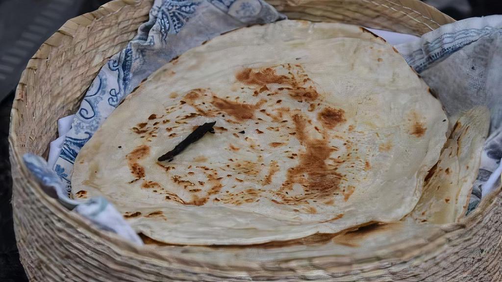 Roti · Whole wheat flatbread baked in a tandoor clay oven.