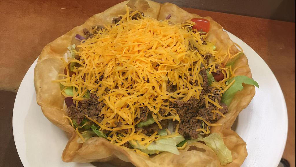 Taco Salad · Your choice of chicken or beef, atop a bed of fresh greens with chopped onions, green pepper, black olives, tomatoes and cheddar cheese. Served in a crispy tortilla shell with a side of sour cream and salsa.
