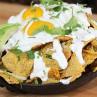 Chilaquiles (V) (Gf) · Spicy. Tortilla chips, salsa verde, chihuahua cheese, cilantro lime crema, avocado, fried eg...
