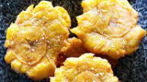 Tostones (V) · Twice fried plantains tossed in sea salt and garlic oil.