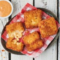 Classic Mac Bites · 4 breaded and fried mac & cheese bites served with a side of Cluck Sauce
