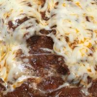 Chicken Parmesan · Breaded, fresh breast of chicken topped with meat sauce and cheese, served with a side of sp...