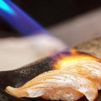 Torched Salmon Nigiri · Two pieces, Open flame, torched salmon nigiri topped with cilantro, house sauce, masago & to...
