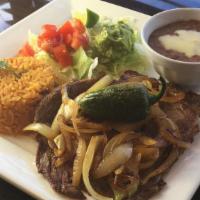 Carne Asada · Grilled steak with onions, served with rice, black beans topped with pico de gallo, salad, a...