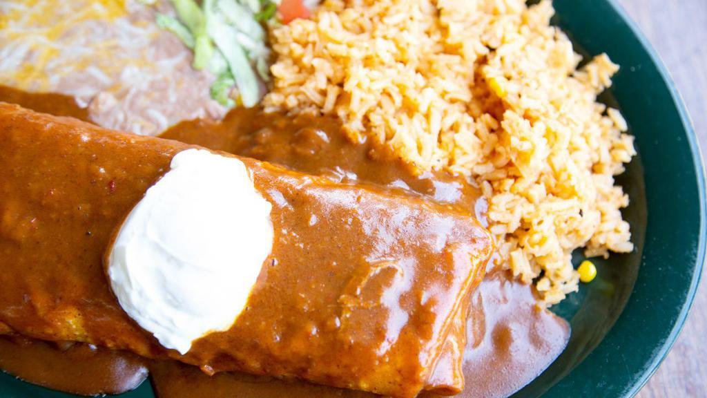 Traditional Chimichanga · Classic favorite! Served with your choice of ground beef, shredded chicken or barbacoa topped with red chile sauce and sour cream. Served with refried beans and rice. Garnished with lettuce and fresh diced tomatoes.