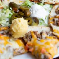 Mexican Pizza · Fried flour tortilla topped with refried beans, ground beef, baked with cheddar cheese. Shre...
