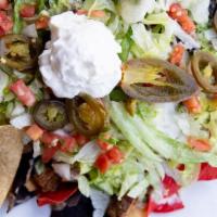 Texas Nachos  · Tri-color tortilla chips with cowboy beans, queso dip, grilled steak and topped with jalapeñ...