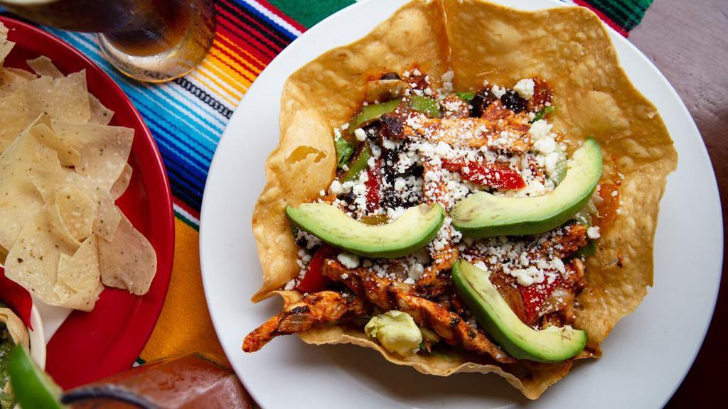 Santa Fe Chicken Salad · Tender grilled chicken sautéed with black olives, onions, green and red peppers and a touch of house salsa. Topped with queso fresco, avocado slices, and a salsa ranch dressing. Served atop mixed greens and a gently fried tortilla.