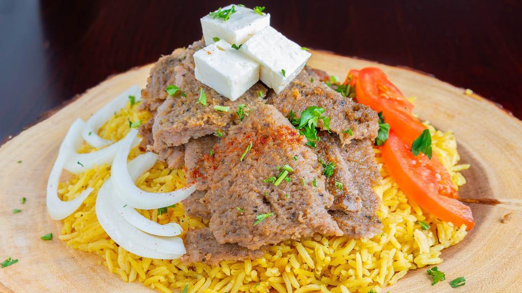 Gyro · Gyro meat cooked on a vertical rotisserie servered with basmati rice or salad or fries. come with pita, tomatoes, onions and teatriki sauce