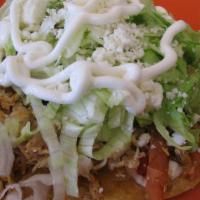 Tostadas · Tostada, a crispy fried tortilla, spread with refried beans and topped with lettuce, tomato,...