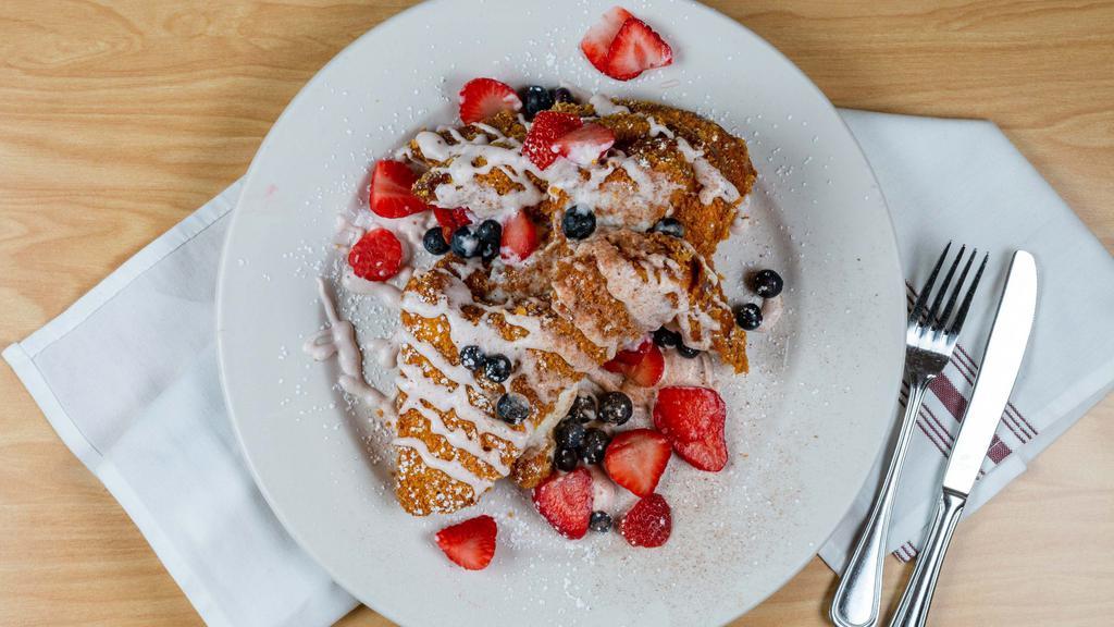 French Churro · Coated in corn flakes and cinnamon sugar, stuffed with our cream cheese filling, topped with fresh berries, and finished with our housemade strawberry cream