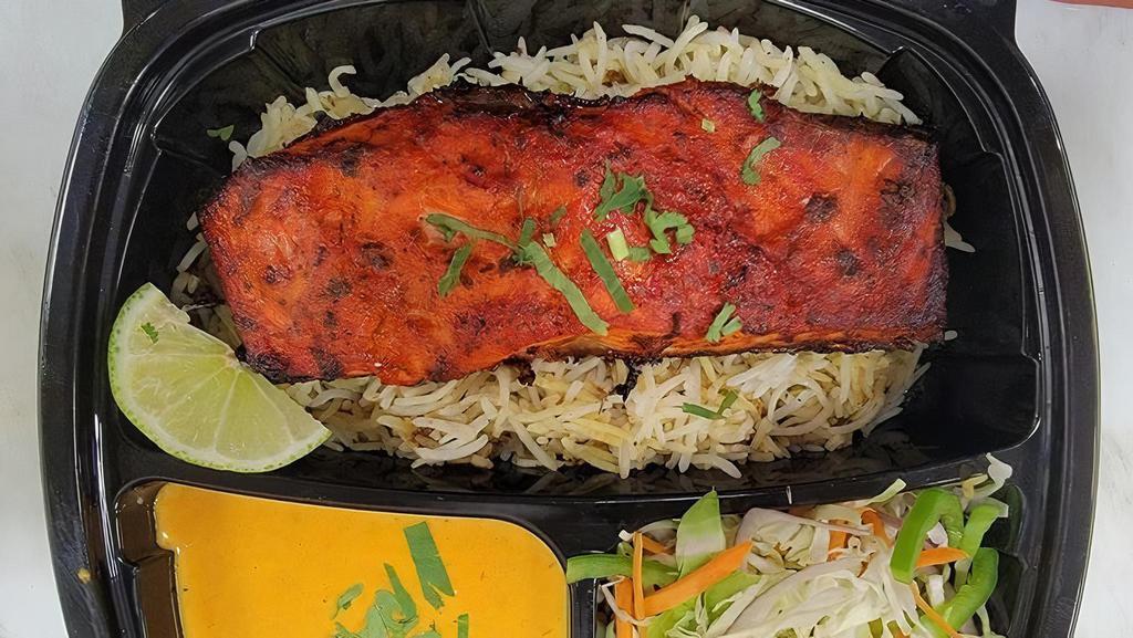 Tandoori Salmon · 8Oz wild caught Salmon fillet marinated in a mildly spiced marinade grilled to perfection served on a bed of biryani rice  with tikka sauce and homemade salad