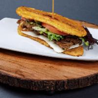 Tradicional Jibarito (Plantain Sandwich) · Bistec (steak) meat sandwich made with flattened, fried green plantains instead of bread, ga...