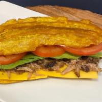 Lechon (Pork) Jibarito · Slow cooked pork sandwich made with flattened, fried green plantains instead of bread, garli...