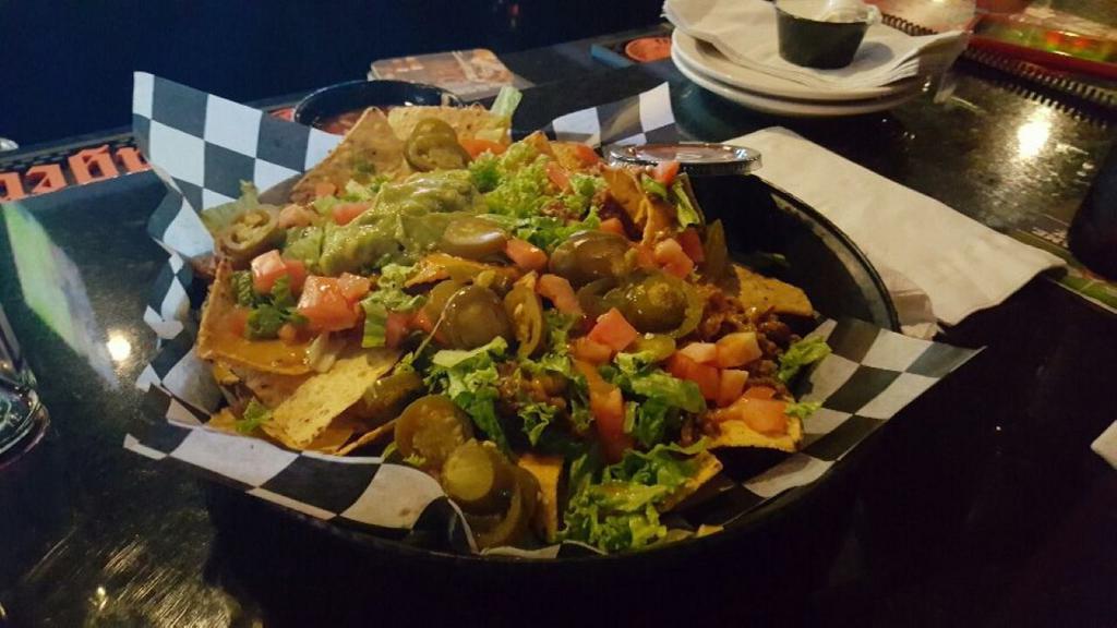 Nacho Grande · Fresh tortilla chips covered with melted cheddar cheese, diced tomatoes, lettuce and jalapeños. Served with guacamole, sour cream and pico de gallo.