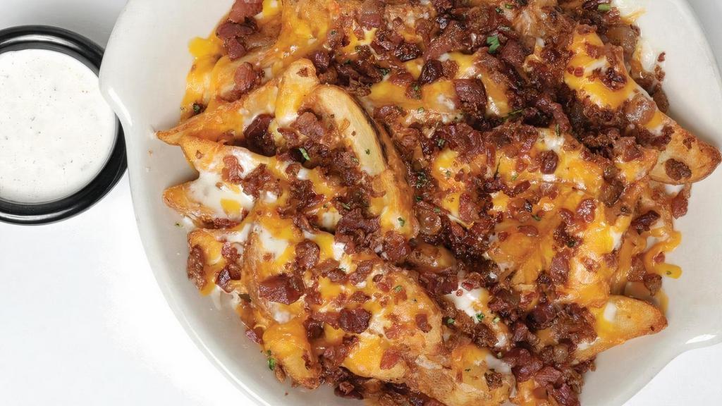 Loaded Fries · Seasoned wedge-cut fries baked with mozzarella and cheddar cheese. Topped with bacon and served with Buddy’s Original Ranch dressing.