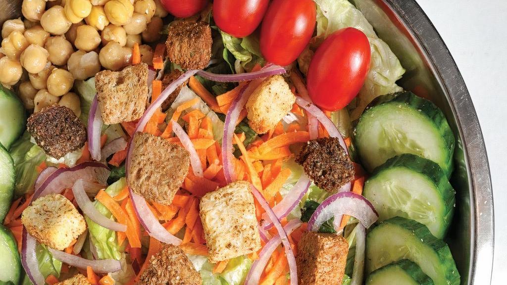 House · Freshly chopped romaine and iceberg lettuce topped with red onions, cucumbers, carrots, garbanzo beans, tomatoes and croutons.