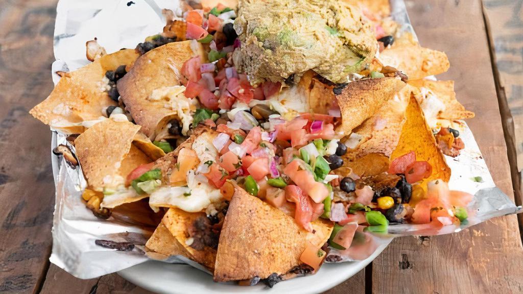 Nachos · Fried white-corn tortilla chips topped with a veggie black bean mix, white cheese blend, our house-made guacamole with hummus mix and pico de gallo. Add chicken, chorizo, ground beef, steak or bbq pork for an additional charge.