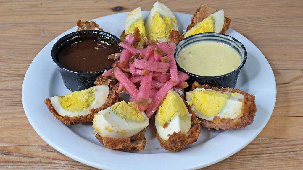 Scotch Eggs · 2 Jumbo Hard-boiled eggs wrapped in our chorizo breading , deep fried & then drizzled w/ a duo of HP & Jalapeno hollandaise sauces & served with our Whiskey Apple Slaw.