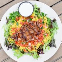 Spicy Steak Salad · A spicy 4 oz. sirloin served atop organic spring & romaine mix with shredded cheddar, pico d...