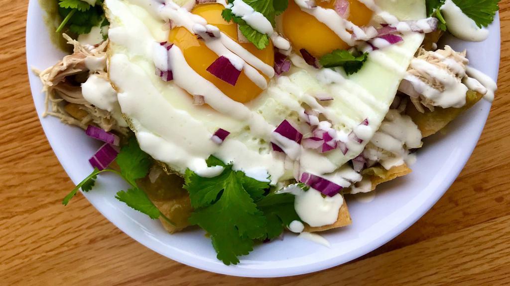 Chilaquiles Verde · two sunny up eggs, corn tortilla chips, salsa verde, pulled chicken, red onions, queso fresco, sour cream, cilantro
