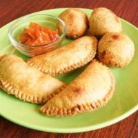 Pastel · Crispy pastry filled with marinated chicken sautéed in tomato and onion sauce.