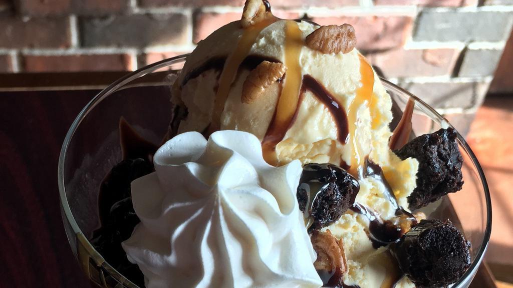 Bear Claw Sundae · Vanilla ice cream drizzled in caramel & hot fudge topped with brownie bites and pecans with whip cream.