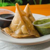 Vegetable Samosa · Crisp patties stuffed with spiced potatoes and green peas. Two pieces.