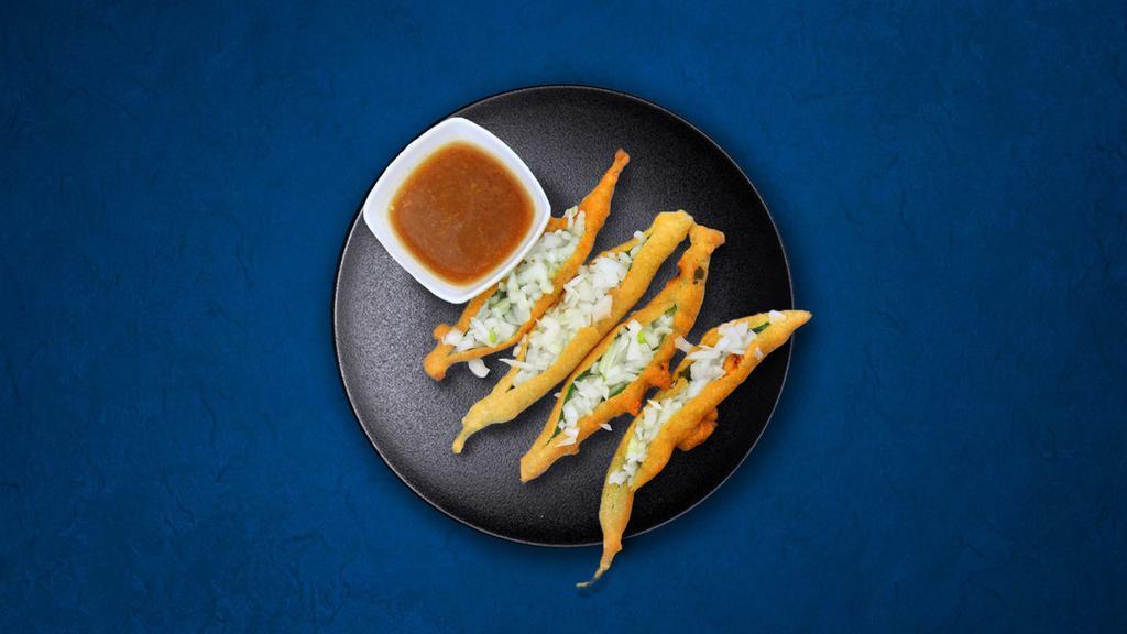 Golden Pepper Fritters · (3 Pcs) Banana peppers slit and dipped in gram flour batter and deep-fried till golden. Served with a side of our homemade tamarind relish.