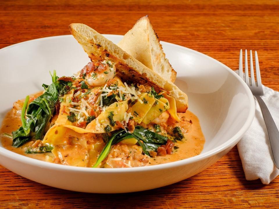 Tuscan Shrimp Tortellini Dinner · Shrimp, spinach, red onion, garlic, and cheese tortellini simmered in oven dried tomato cream with basil pesto drizzle, and garlic sourdough