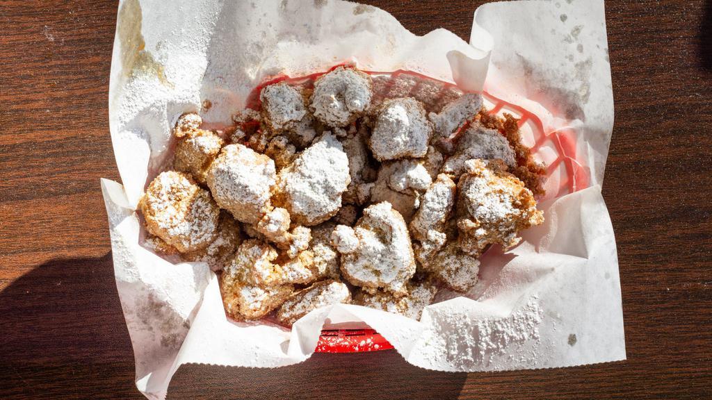 Chicken & Waffle Bites · Bite sized pieces of chicken, dipped in waffle batter and deep fried, then topped with powdered sugar.