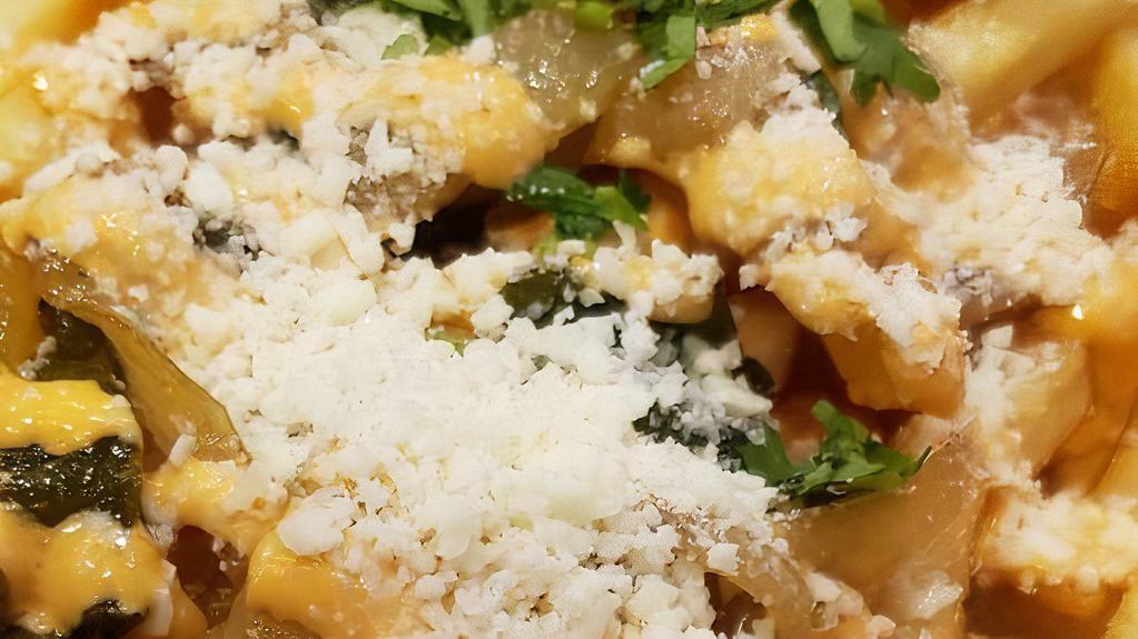 Cotija Fries · French fries fried with poblano peppers and onions smothered with chipotle aioli, cilantro and cotija cheese.
