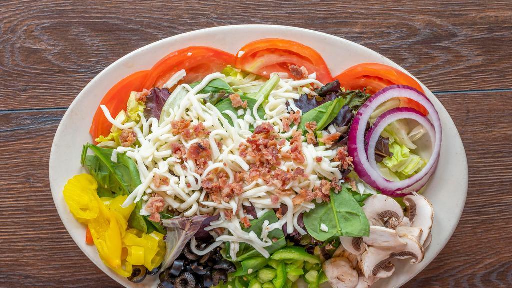 The Big Chopped · Mozzarella, bacon, onions, tomatoes, green peppers, mushrooms, black olives and banana peppers on a bed of fresh lettuce with our olive oil Italian dressing.