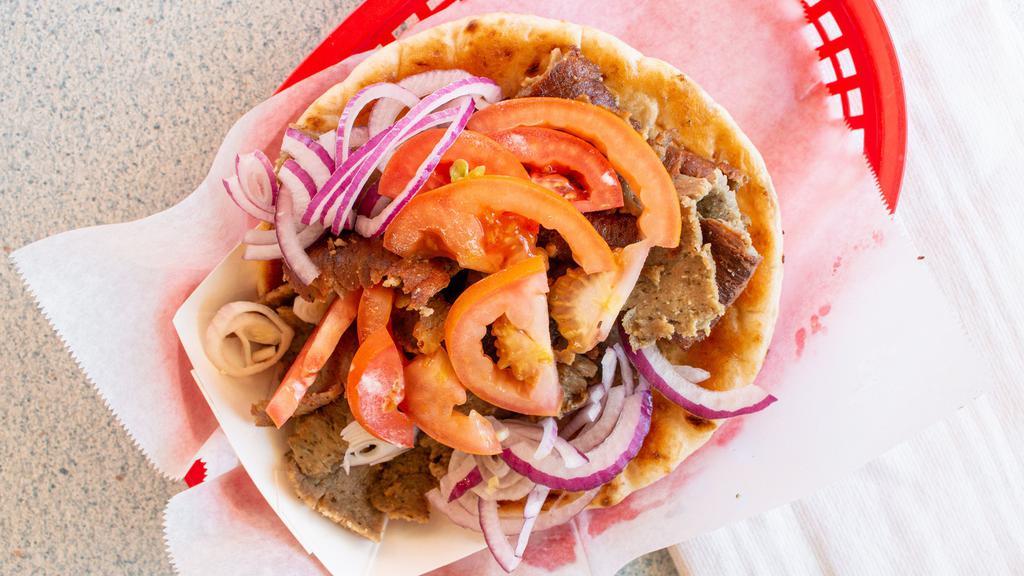 Gyro · Gyros a classic Greek sandwich, with meat cut from a spit, wrapped in a pita, onions , tomatoes and topped with tzatziki (yogurt sauce)